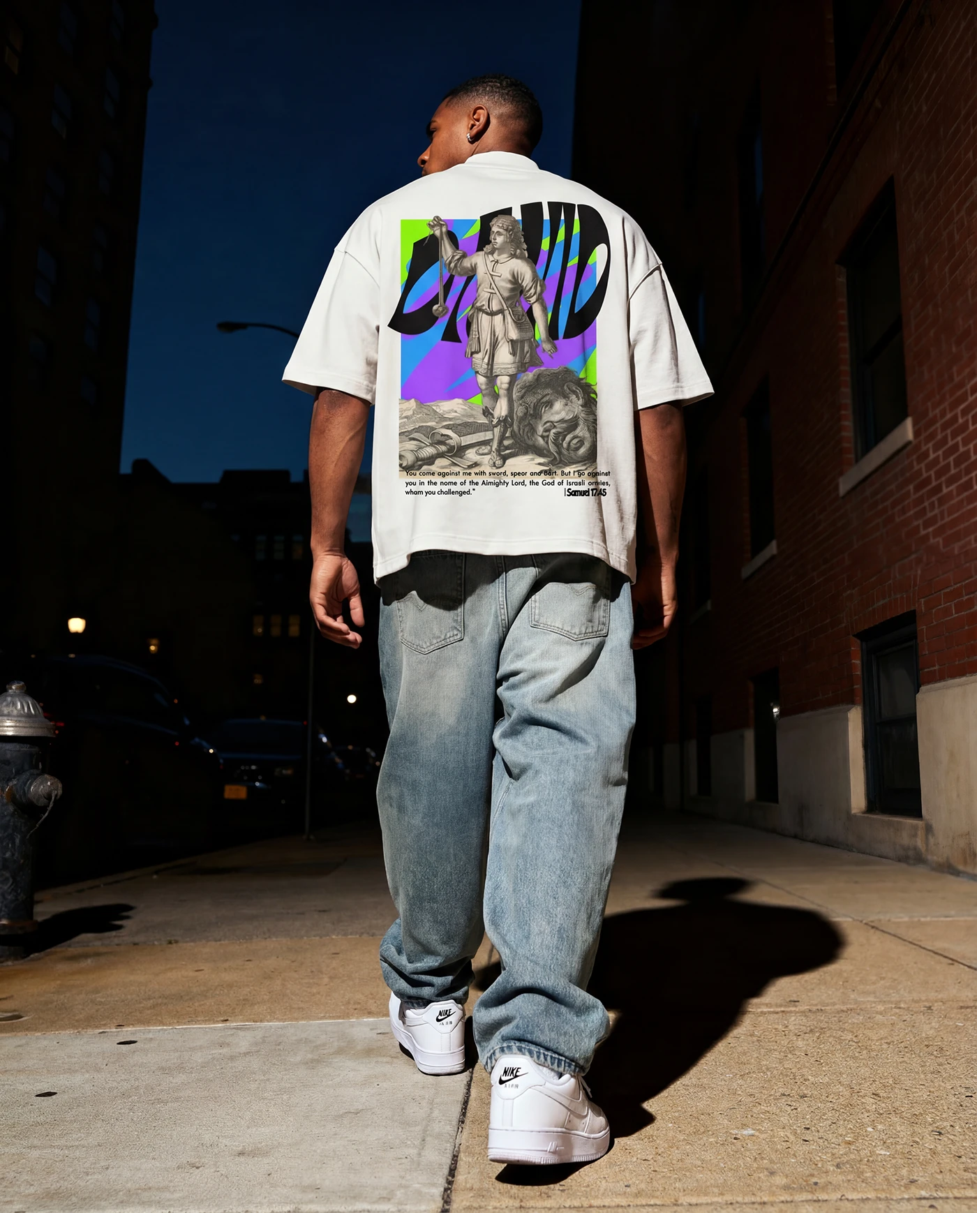 Model walking down a city street at night in the Timeless graphic tee and baggy jeans