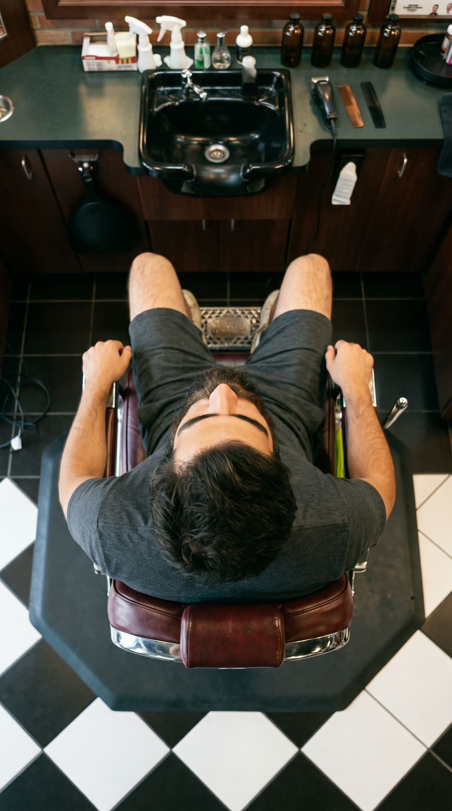 Overhead view of a client in the barber chair on the checkered floor